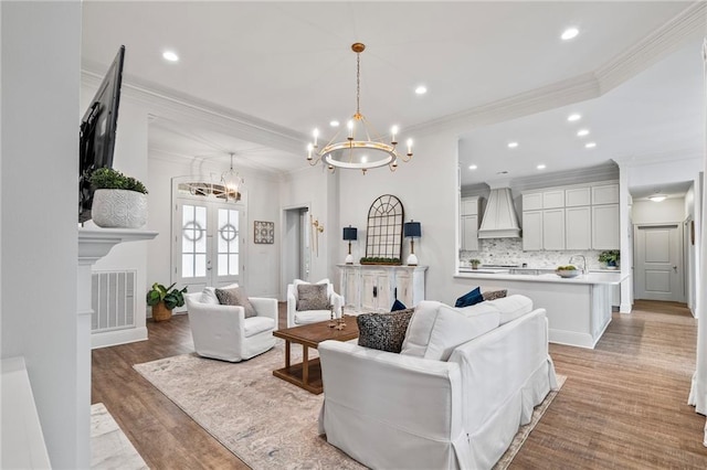 336 Rue St, Emilion, Covington, LA 70433 - living area with a chandelier, ornamental molding, light wood finished floors, recessed lighting, and french doors