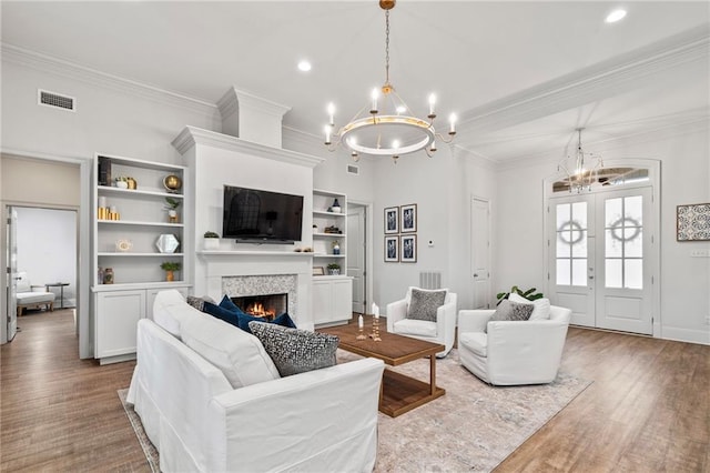 336 Rue St, Emilion, Covington, LA 70433 - living room with a chandelier, a lit fireplace, wood finished floors, ornamental molding, and recessed lighting
