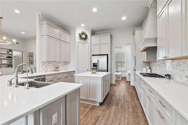336 Rue St, Emilion, Covington, LA 70433 - kitchen with stainless steel appliances, custom exhaust hood, a sink, a kitchen island, and wood finished floors