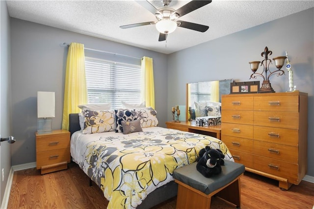 126 Silverwood Dr, Slidell, LA 70461 - bedroom featuring wood finished floors, a textured ceiling, baseboards, and a ceiling fan