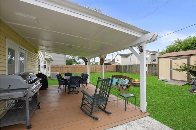 126 Silverwood Dr, Slidell, LA 70461 - wooden terrace featuring outdoor dining space, a storage unit, grilling area, and an outbuilding