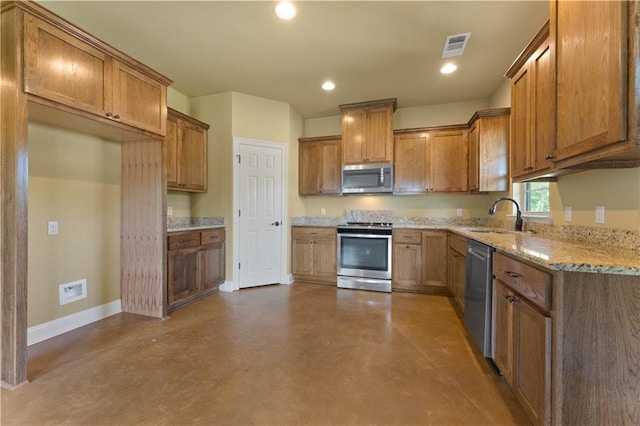 200 Cotton Ln, Hammond, LA 70401 - kitchen with stainless steel appliances, a sink, concrete floors, baseboards, and brown cabinetry