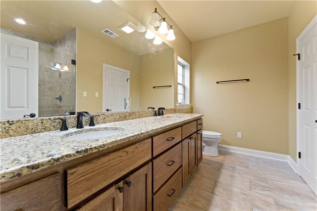 200 Cotton Ln, Hammond, LA 70401 - full bathroom featuring baseboards, double vanity, tiled shower, and toilet