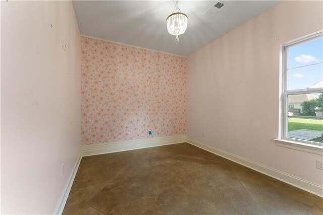 200 Cotton Ln, Hammond, LA 70401 - empty room with baseboards, concrete flooring, a chandelier, and wallpapered walls