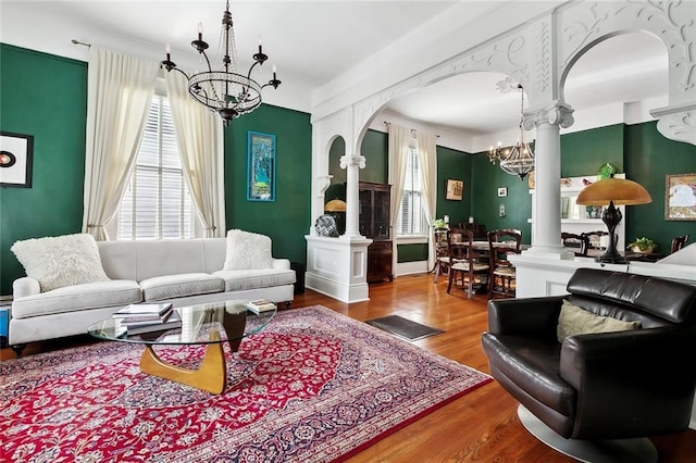 5925 Annunciation St, New Orleans, LA 70115 - living room featuring a chandelier, decorative columns, plenty of natural light, and wood finished floors