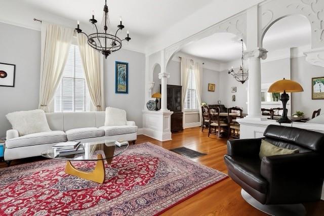 5925 Annunciation St, New Orleans, LA 70115 - living area featuring ornate columns, a chandelier, and plenty of natural light
