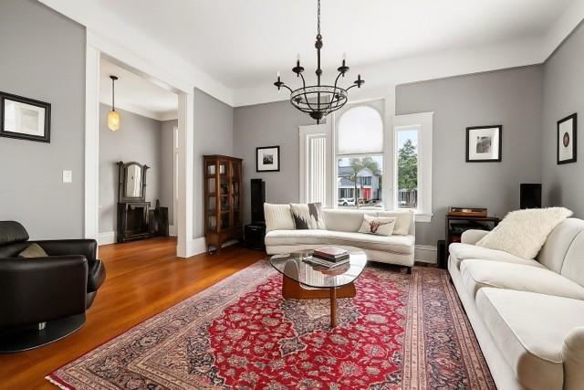 5925 Annunciation St, New Orleans, LA 70115 - living room featuring a chandelier and wood finished floors