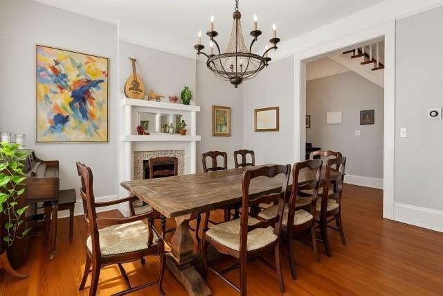 5925 Annunciation St, New Orleans, LA 70115 - dining area featuring a chandelier, wood finished floors, and a fireplace