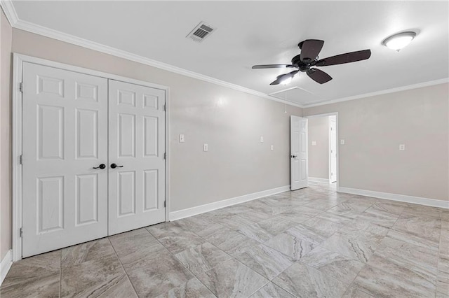 unfurnished bedroom with light marble finish floors, attic access, baseboards, crown molding, and a closet