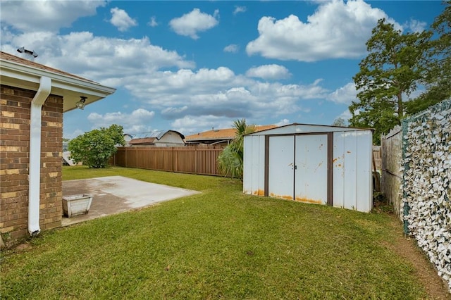 view of yard featuring a patio area, a storage shed, and an outbuilding