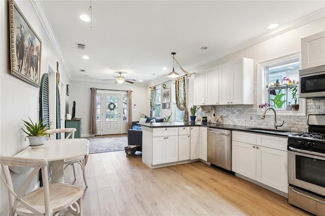 3222 Orleans Ave, New Orleans, LA 70119 - kitchen with stainless steel appliances, a sink, dark countertops, open floor plan, and a peninsula