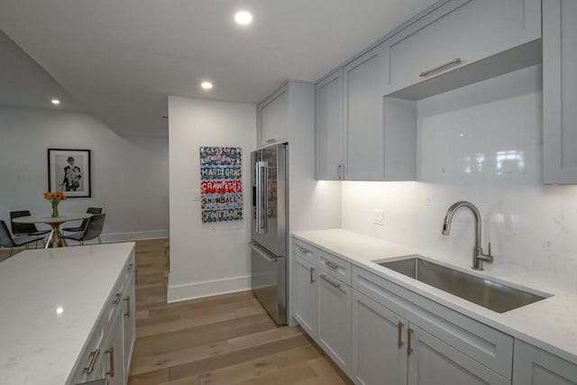 1115 Upperline St Unit 1115, New Orleans, LA 70115 - kitchen with high end fridge, a sink, light wood-style floors, recessed lighting, and baseboards