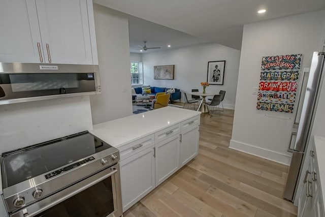 1115 Upperline St Unit 1115, New Orleans, LA 70115 - kitchen with appliances with stainless steel finishes, light wood-type flooring, white cabinets, ceiling fan, and light countertops