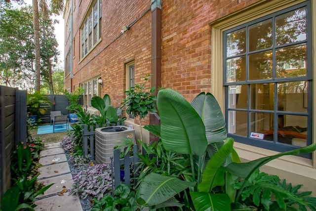 1115 Upperline St Unit 1115, New Orleans, LA 70115 - view of side of home featuring brick siding, a fenced backyard, and central air condition unit