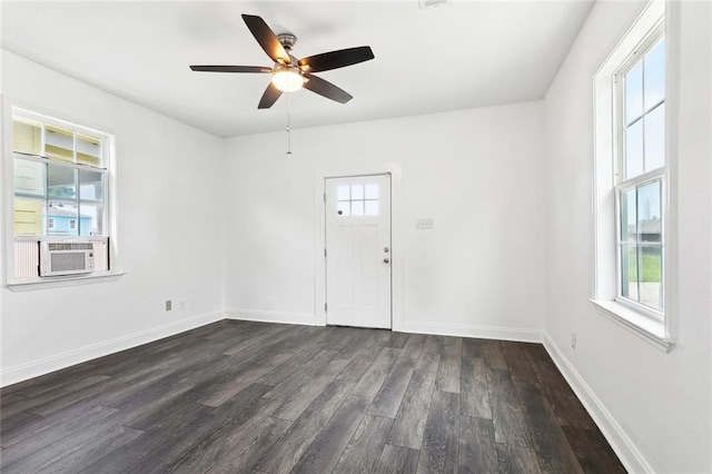 unfurnished room featuring healthy amount of natural light, dark wood-style flooring, a ceiling fan, and baseboards