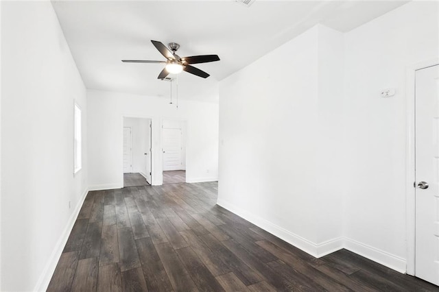 empty room featuring ceiling fan, dark wood-style floors, and baseboards