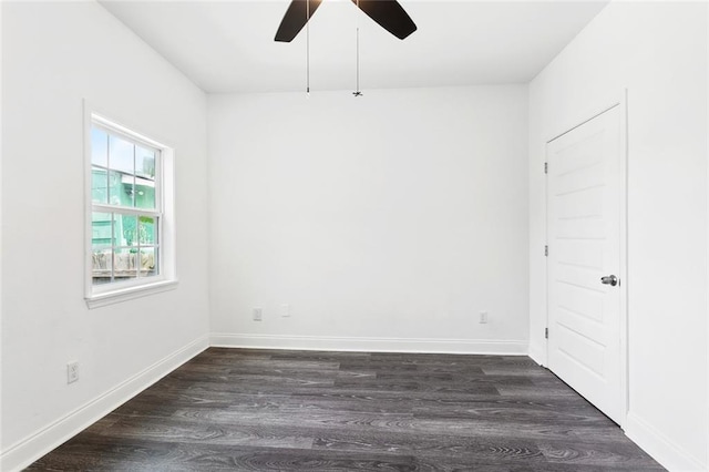 unfurnished room with ceiling fan, dark wood finished floors, and baseboards