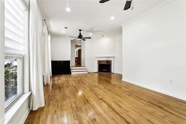 527 S Filmore St, Covington, LA 70433 - unfurnished living room with a ceiling fan, ornamental molding, light wood-style flooring, recessed lighting, and a brick fireplace