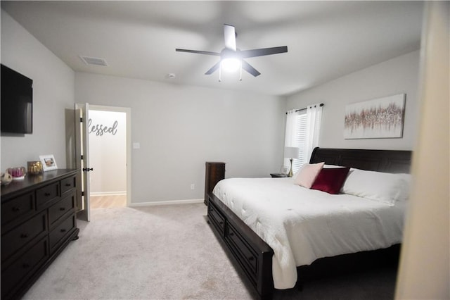 bedroom with light colored carpet, ceiling fan, and baseboards