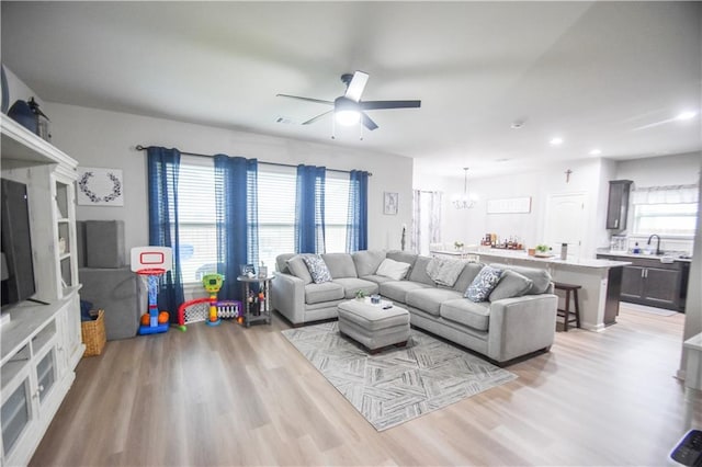 living room featuring light wood-style floors, a chandelier, a ceiling fan, and recessed lighting