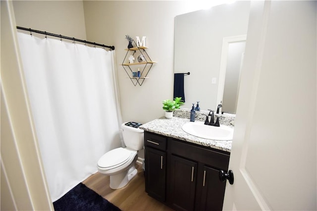 full bathroom featuring wood finished floors, toilet, vanity, and curtained shower