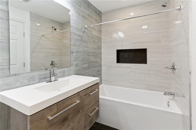 629 Lesseps St, New Orleans, LA 70117 - bathroom with bathtub / shower combination, tile walls, vanity, and backsplash