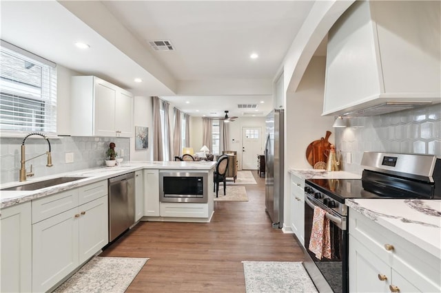 240810 Saint Anthony St, New Orleans, LA 70119 - kitchen with stainless steel appliances, a sink, custom range hood, backsplash, and recessed lighting