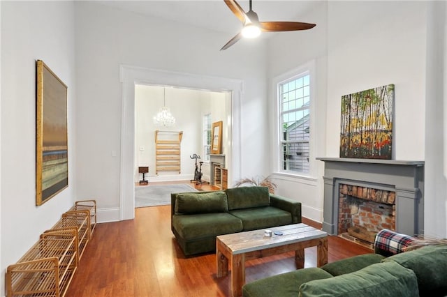 2224 Dumaine St, New Orleans, LA 70119 - living area with a fireplace, wood finished floors, a ceiling fan, baseboards, and a chandelier