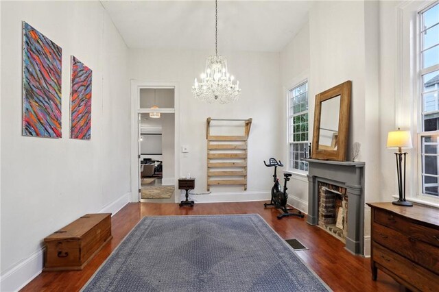 2224 Dumaine St, New Orleans, LA 70119 - workout area with dark wood-style floors, plenty of natural light, a chandelier, and a fireplace