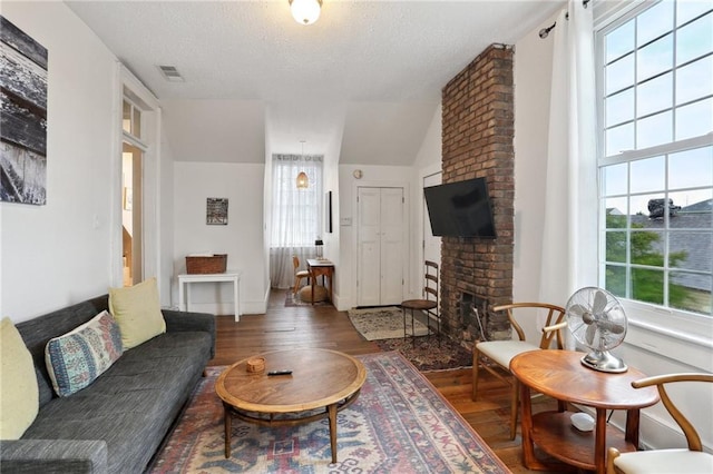 2224 Dumaine St, New Orleans, LA 70119 - living area featuring wood finished floors, a fireplace, a textured ceiling, and baseboards