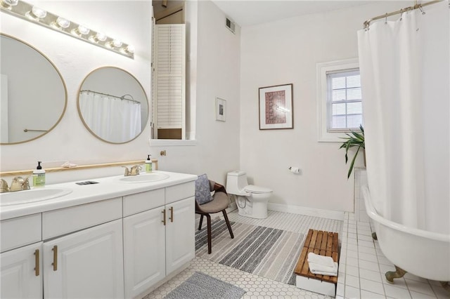2224 Dumaine St, New Orleans, LA 70119 - full bath featuring toilet, double vanity, a freestanding bath, tile patterned floors, and curtained shower