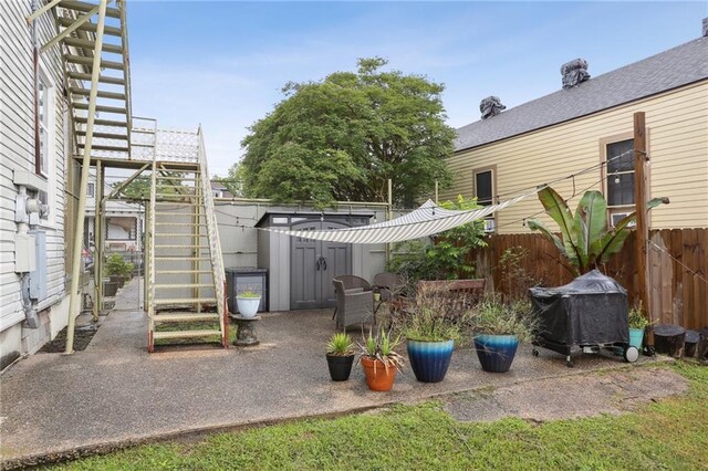 2224 Dumaine St, New Orleans, LA 70119 - view of patio / terrace with stairs, a fenced backyard, a shed, and an outdoor structure