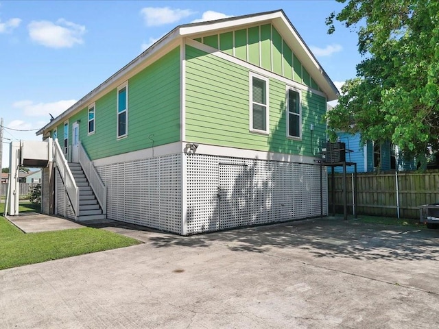 5840 Eads St, New Orleans, LA 70122 - view of side of home featuring stairs, board and batten siding, and driveway