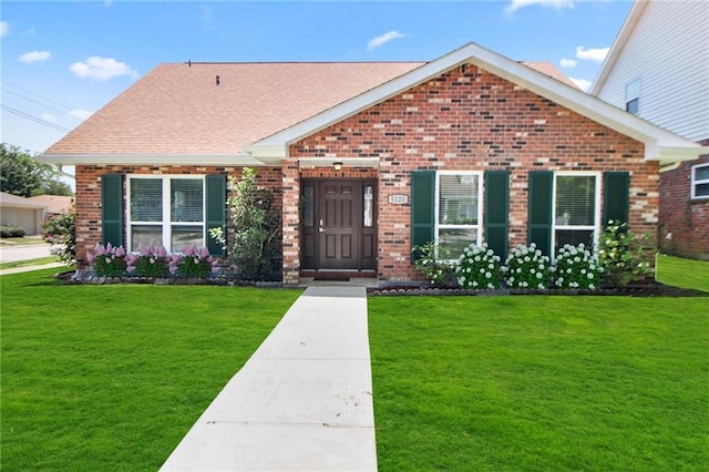 5120 Belle Dr, Metairie, LA 70006 - view of front of house featuring brick siding, a front yard, and a shingled roof
