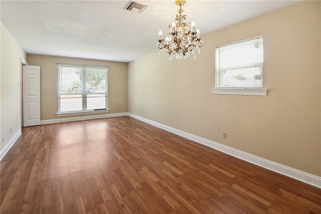 5120 Belle Dr, Metairie, LA 70006 - unfurnished room featuring a chandelier, wood finished floors, baseboards, and a textured ceiling