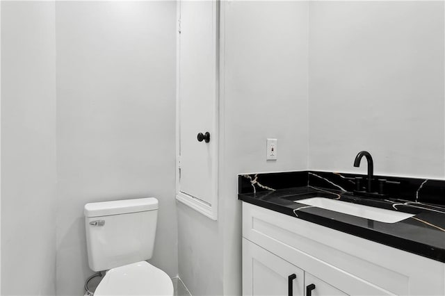 half bathroom with vanity and toilet