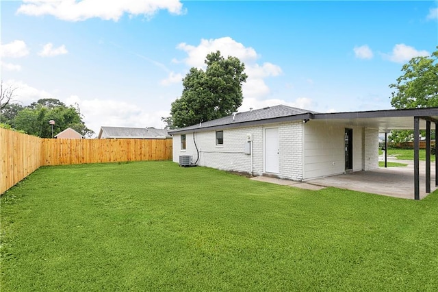 rear view of property with central AC, a carport, and brick siding