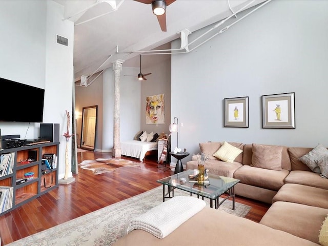 living room featuring ceiling fan, high vaulted ceiling, wood finished floors, and decorative columns