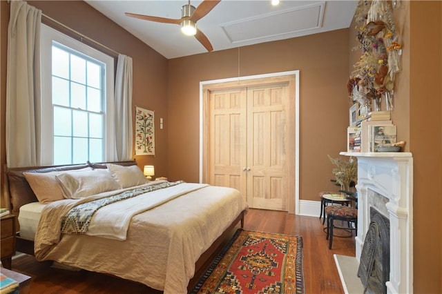 3217 Dauphine St, New Orleans, LA 70117 - bedroom featuring dark wood finished floors, a fireplace, a ceiling fan, a closet, and baseboards