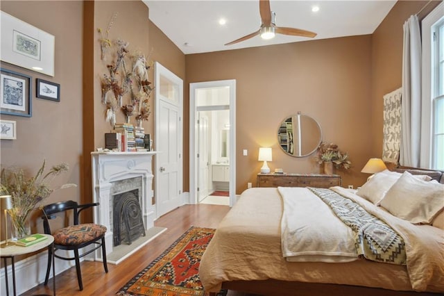 3217 Dauphine St, New Orleans, LA 70117 - bedroom with wood finished floors, a fireplace with raised hearth, ensuite bath, and recessed lighting