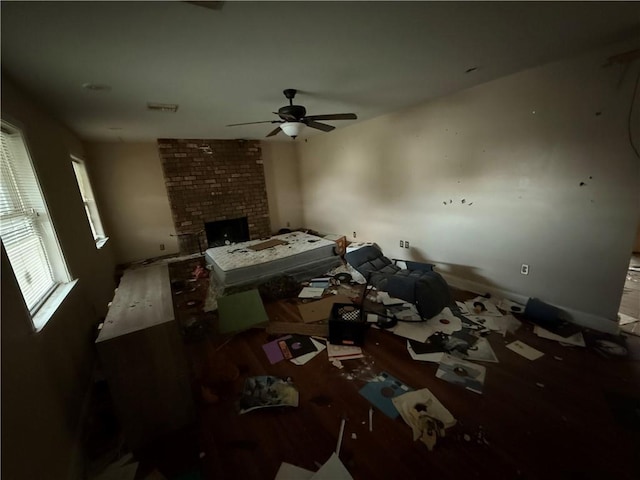 unfurnished living room featuring a brick fireplace, ceiling fan, and wood finished floors