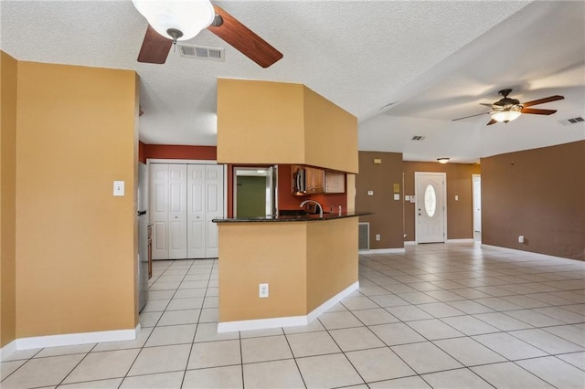 2728 Sprig Dr, Marrero, LA 70072 - kitchen featuring ceiling fan, dark countertops, light tile patterned flooring, a peninsula, and baseboards