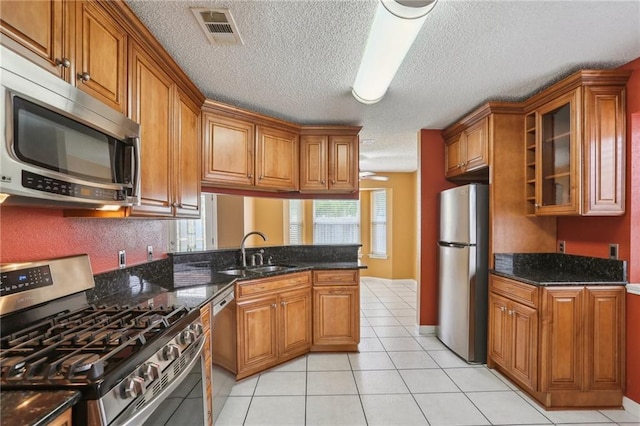 2728 Sprig Dr, Marrero, LA 70072 - kitchen with appliances with stainless steel finishes, a sink, brown cabinets, and a textured ceiling