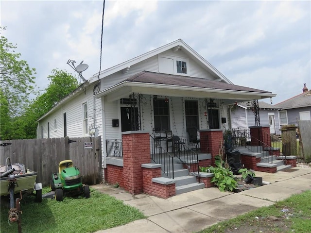 view of front of house featuring covered porch and fence
