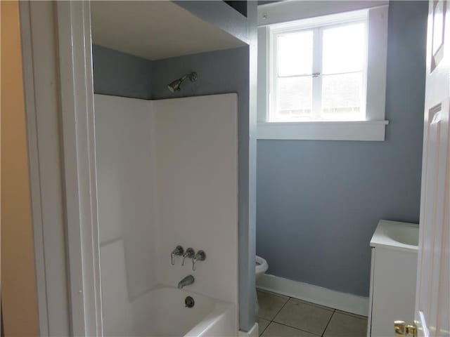 full bath featuring tile patterned floors, toilet, washtub / shower combination, vanity, and baseboards