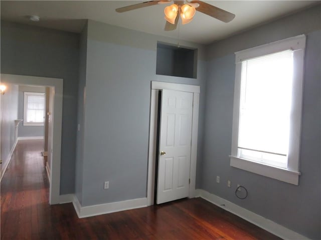 unfurnished bedroom featuring dark wood-type flooring, baseboards, and a ceiling fan