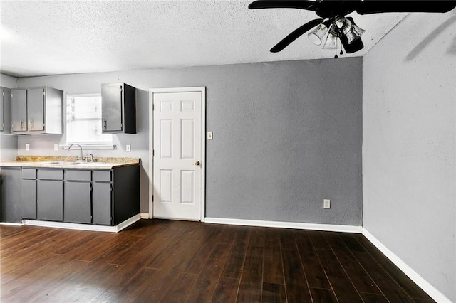 27 Pinewood Ct, New Orleans, LA 70114 - kitchen with gray cabinets, a textured wall, light countertops, dark wood-style flooring, and a textured ceiling