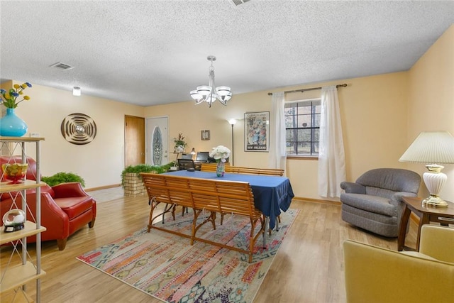 41376 Dunson Rd, Ponchatoula, LA 70454 - rec room with a chandelier, a textured ceiling, light wood finished floors, and baseboards