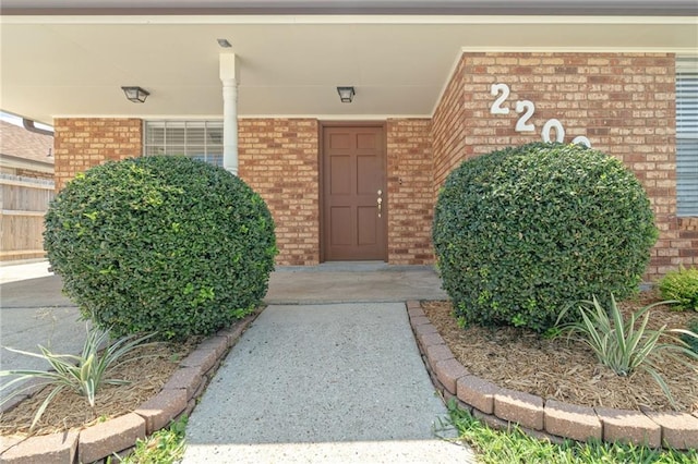 view of exterior entry featuring brick siding