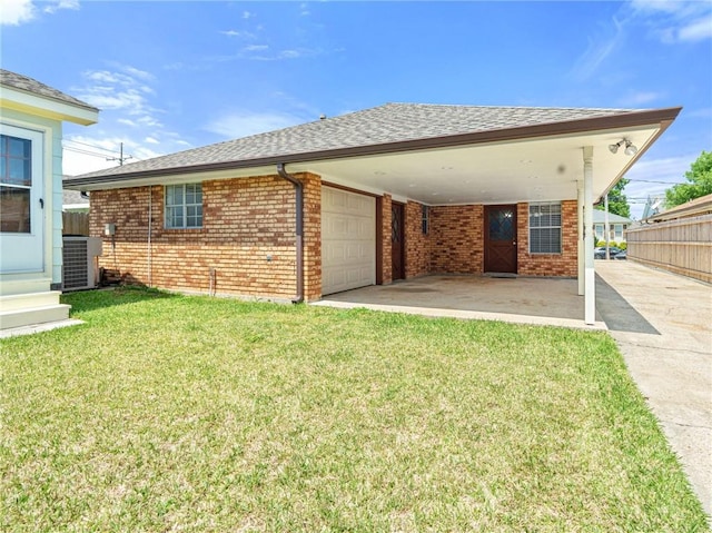 rear view of property featuring central AC, driveway, a yard, brick siding, and roof with shingles